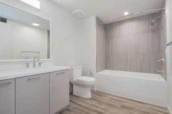 A white bathroom with a toilet, sink, and bathtub.
